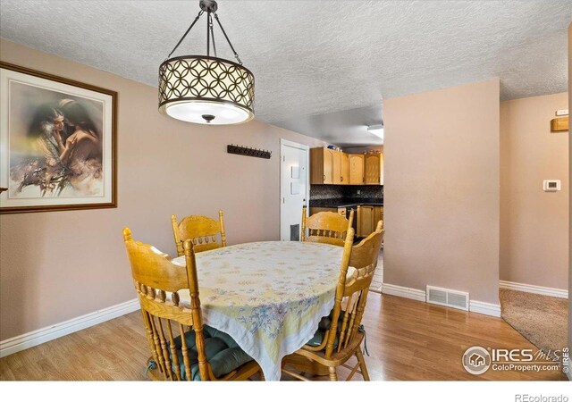 719 Marshall Pl, Berthoud, CO 80513 - dining space featuring light wood-style floors, baseboards, and a textured ceiling