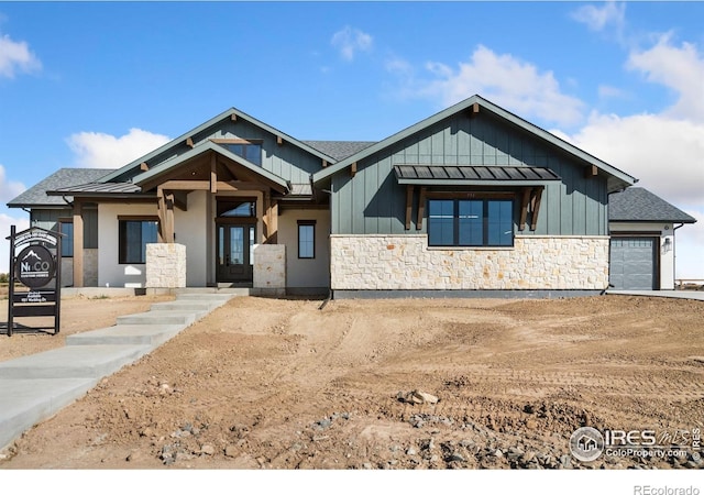 951 Warbling Dr, Windsor, CO 80550 - view of front of house with stone siding, a standing seam roof, and an attached garage