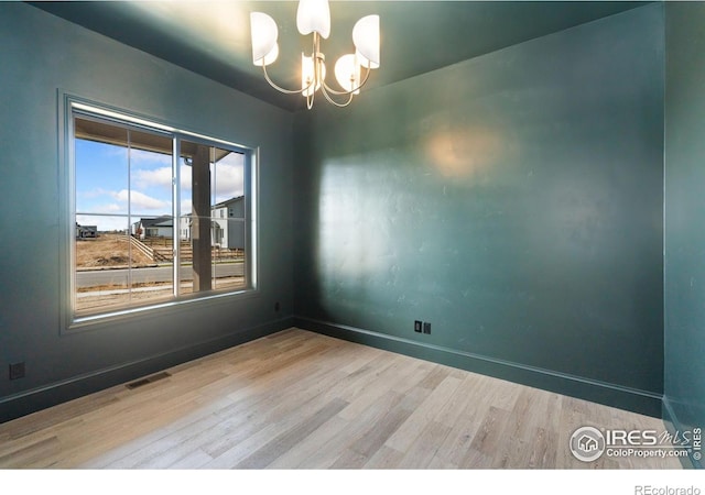 951 Warbling Dr, Windsor, CO 80550 - empty room featuring wood finished floors, a chandelier, and baseboards