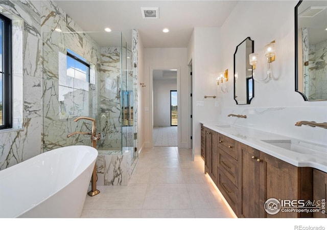 951 Warbling Dr, Windsor, CO 80550 - bathroom with a freestanding tub, a marble finish shower, double vanity, and tile patterned floors