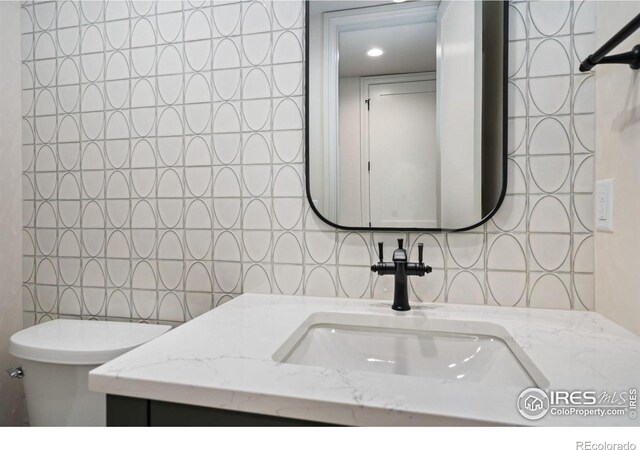 951 Warbling Dr, Windsor, CO 80550 - bathroom with backsplash, toilet, vanity, and recessed lighting