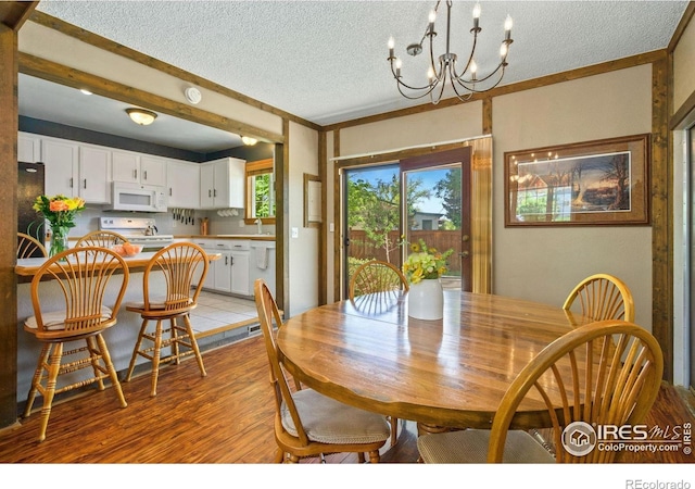 5930 Mars Dr, Fort Collins, CO 80525 - dining area featuring a chandelier, a textured ceiling, and light wood-style flooring