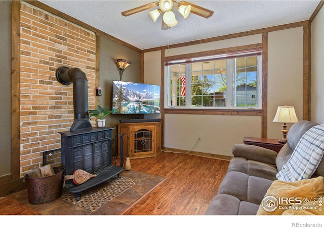 5930 Mars Dr, Fort Collins, CO 80525 - living room featuring a wood stove, wood finished floors, ceiling fan, and a textured ceiling