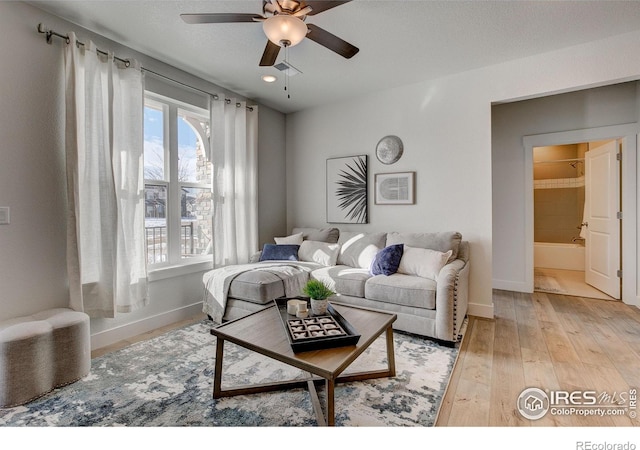 living area featuring ceiling fan, baseboards, light wood-style flooring, and recessed lighting