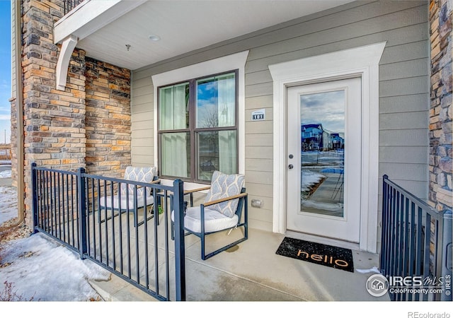 doorway to property featuring stone siding and a porch