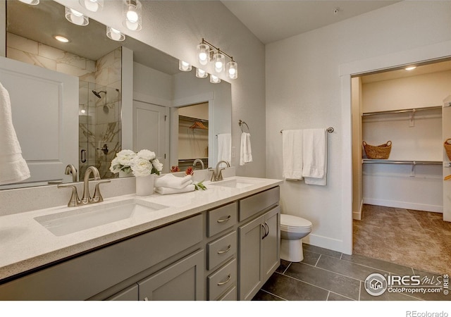 full bathroom featuring a shower stall, double vanity, toilet, tile patterned floors, and baseboards