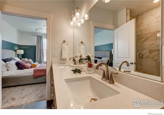 bathroom with ensuite bathroom, double vanity, and a tile shower