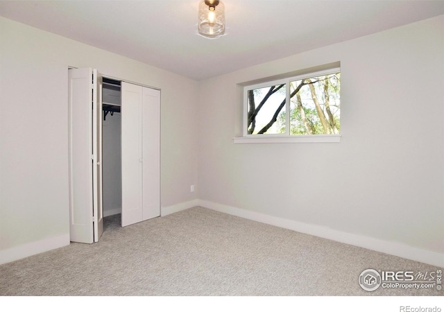 unfurnished bedroom featuring carpet, baseboards, and a closet