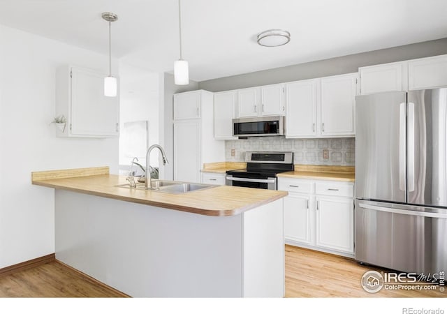 1013 Alsace Way, Lafayette, CO 80026 - kitchen featuring stainless steel appliances, a sink, light wood-type flooring, light countertops, and decorative backsplash
