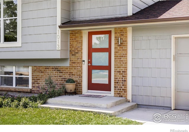 1013 Alsace Way, Lafayette, CO 80026 - property entrance with brick siding, roof with shingles, and a garage