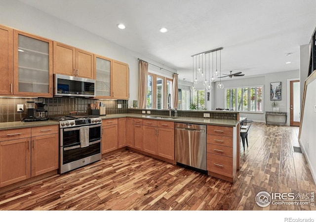 5145 Denver St, Boulder, CO 80304 - kitchen featuring stainless steel appliances, dark wood finished floors, a peninsula, a sink, and backsplash