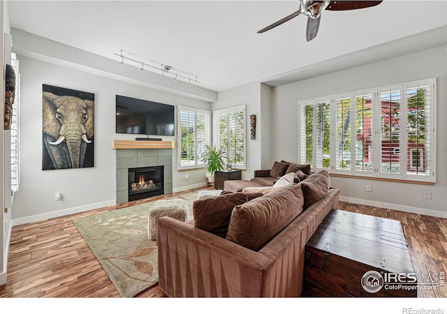 5145 Denver St, Boulder, CO 80304 - living room featuring track lighting, ceiling fan, baseboards, wood finished floors, and a tiled fireplace