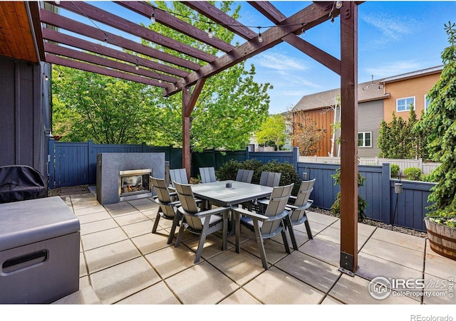5145 Denver St, Boulder, CO 80304 - view of patio with a glass covered fireplace, outdoor dining space, a fenced backyard, and a pergola