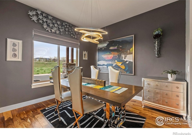 660 Deer Meadow Dr, Loveland, CO 80537 - dining area with a chandelier, baseboards, and wood finished floors