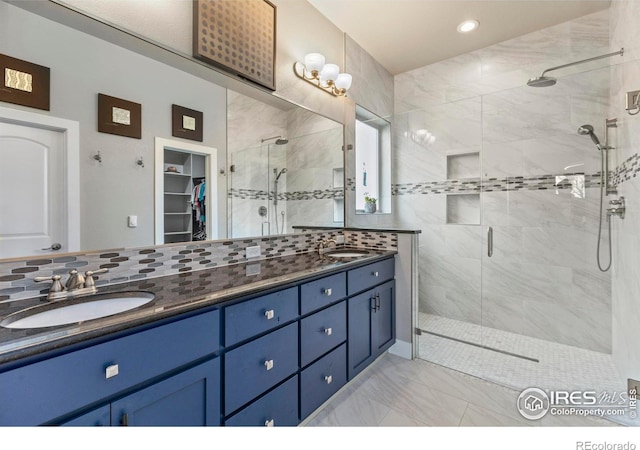 660 Deer Meadow Dr, Loveland, CO 80537 - bathroom with a shower stall, double vanity, marble look tiles, a spacious closet, and recessed lighting