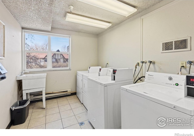 3030 Oneal Pkwy Unit 10, Boulder, CO 80301 - community laundry room featuring independent washer and dryer, a baseboard radiator, a textured ceiling, and light tile patterned floors