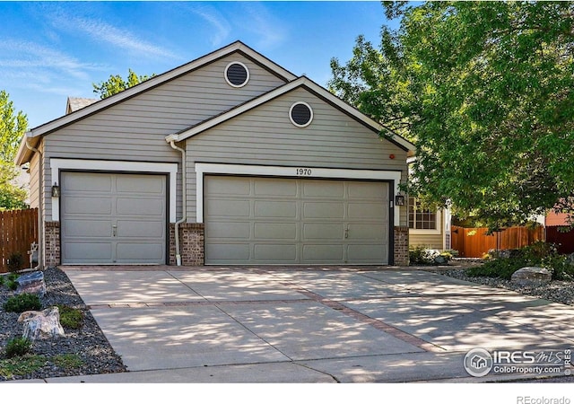 1970 Hamron Ct, Erie, CO 80516 - view of front facade with brick siding, a garage, driveway, fence, and an outdoor structure
