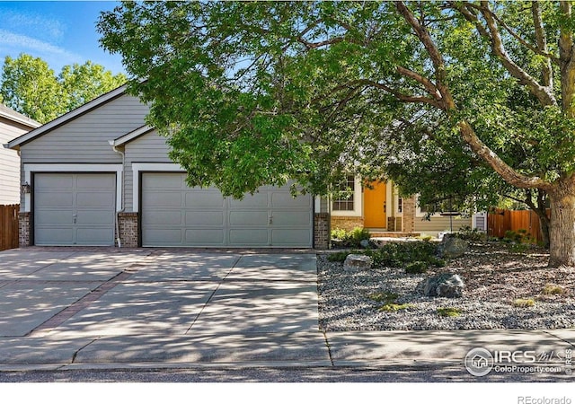 1970 Hamron Ct, Erie, CO 80516 - obstructed view of property with brick siding, a garage, driveway, and fence