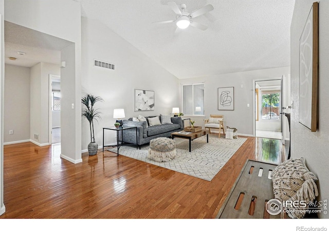 1970 Hamron Ct, Erie, CO 80516 - living room with wood finished floors, ceiling fan, baseboards, high vaulted ceiling, and a textured ceiling