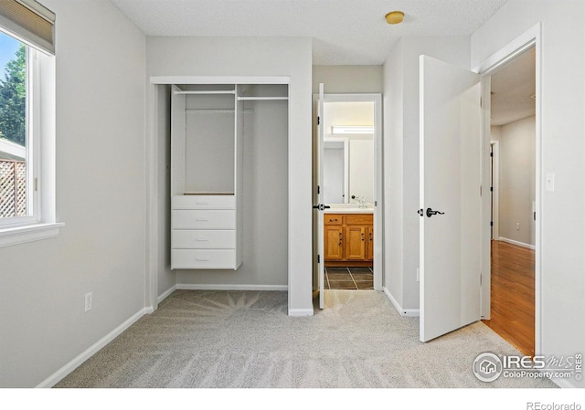 1970 Hamron Ct, Erie, CO 80516 - unfurnished bedroom featuring light colored carpet, baseboards, a closet, and ensuite bath