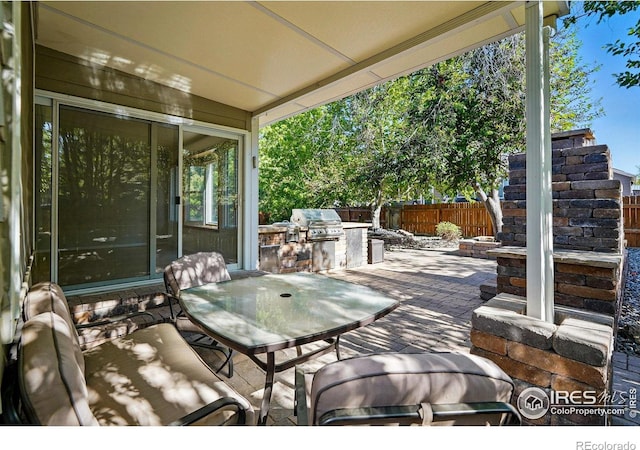 1970 Hamron Ct, Erie, CO 80516 - view of patio with an outdoor kitchen, fence, a grill, and outdoor dining area