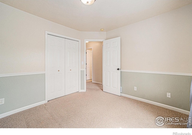 unfurnished bedroom featuring carpet flooring, a closet, and baseboards