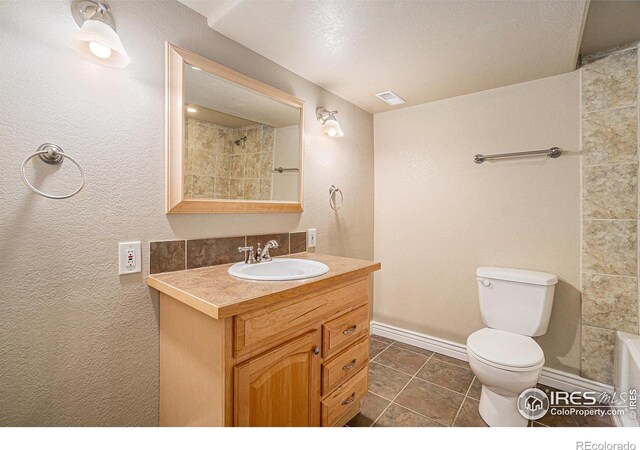 bathroom with toilet, vanity, tile patterned floors, and baseboards