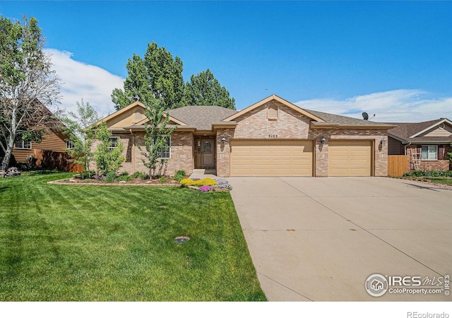 ranch-style home with brick siding, concrete driveway, an attached garage, a front lawn, and roof with shingles