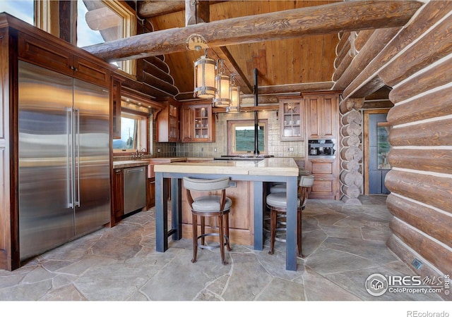 9126 Gold Mine Rd, Loveland, CO 80538 - kitchen with wooden ceiling, stainless steel appliances, plenty of natural light, light countertops, and stone flooring