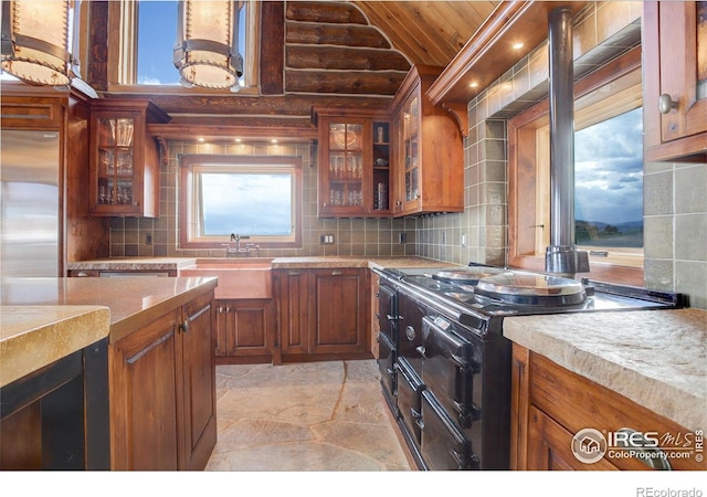 9126 Gold Mine Rd, Loveland, CO 80538 - kitchen featuring double oven range, light stone finish floors, stainless steel built in refrigerator, a sink, and decorative backsplash