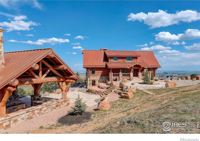 9126 Gold Mine Rd, Loveland, CO 80538 - back of house featuring stone siding, a gazebo, and metal roof