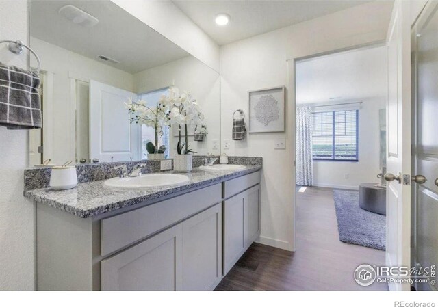 4204 Sandstone Dr, Mead, CO 80504 - full bathroom with double vanity, wood finished floors, and baseboards