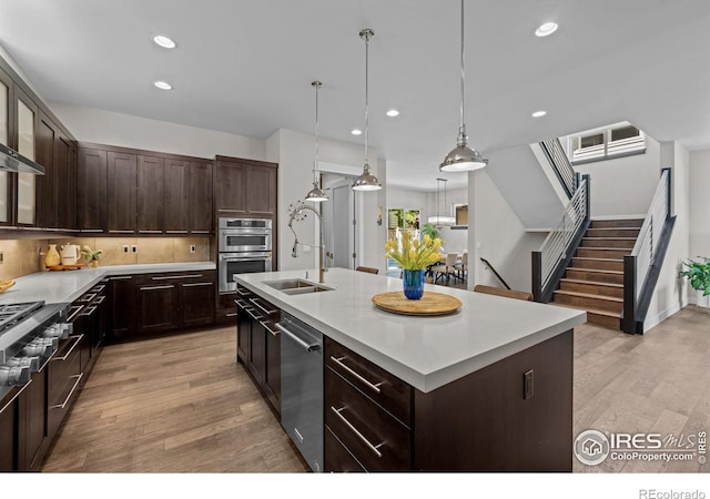 3663 Silverton St, Boulder, CO 80301 - kitchen featuring appliances with stainless steel finishes, light wood-style flooring, light countertops, recessed lighting, and dark brown cabinetry