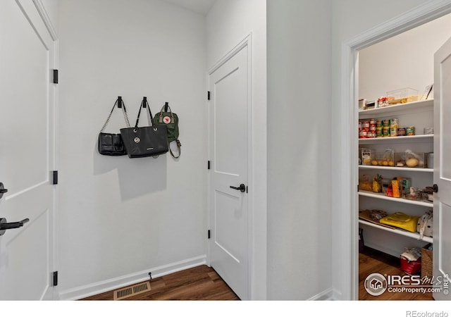 mudroom with dark wood-style flooring and baseboards