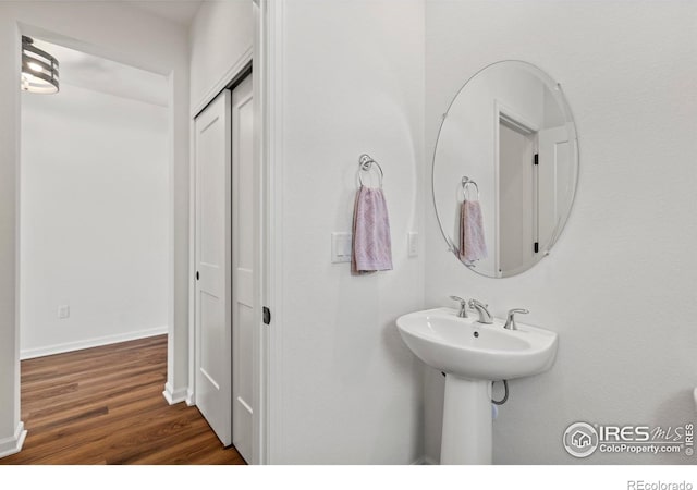 bathroom with wood finished floors and baseboards