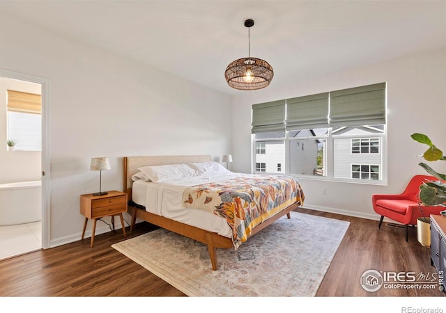 bedroom featuring wood finished floors and baseboards