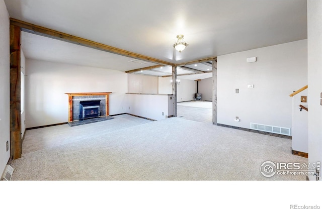 unfurnished living room featuring carpet, a fireplace, and baseboards