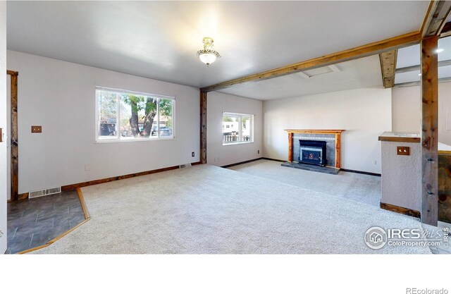 unfurnished living room featuring carpet, a fireplace, and baseboards