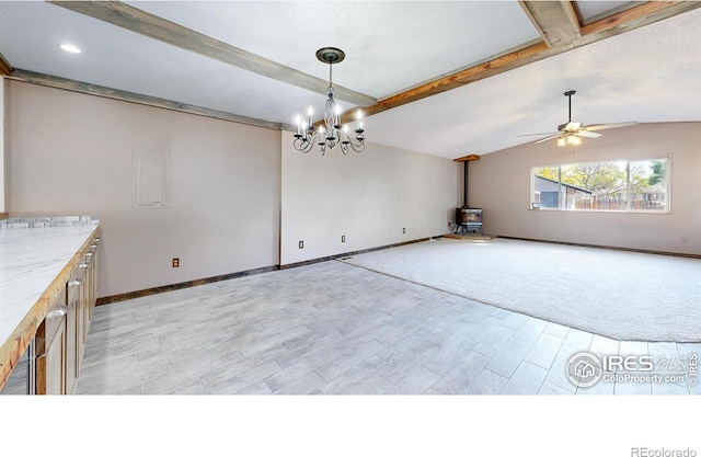 unfurnished dining area with light wood-type flooring, baseboards, ceiling fan, a wood stove, and a chandelier
