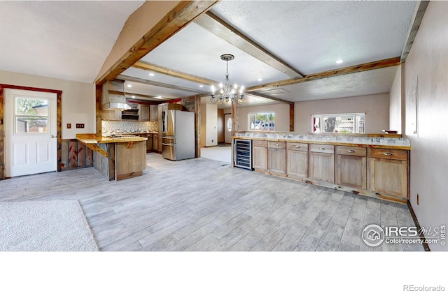 kitchen with stainless steel fridge, a peninsula, wine cooler, light wood finished floors, and a chandelier