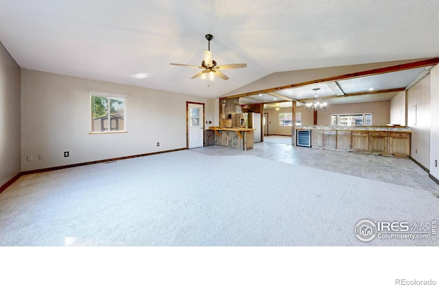 unfurnished living room featuring light colored carpet, baseboards, wine cooler, a chandelier, and vaulted ceiling