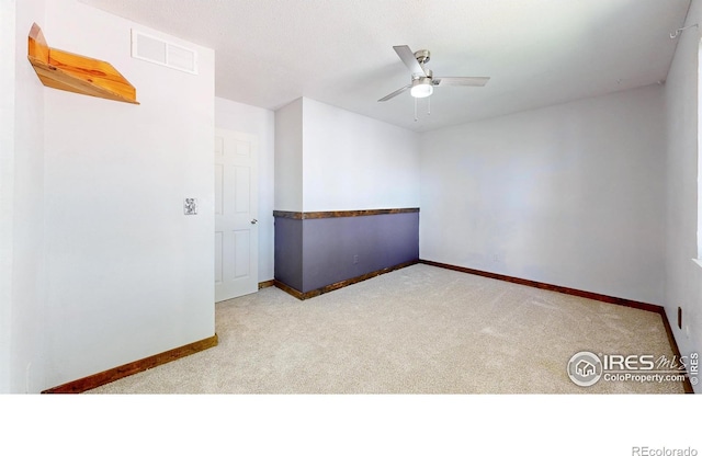 spare room featuring carpet, baseboards, and ceiling fan