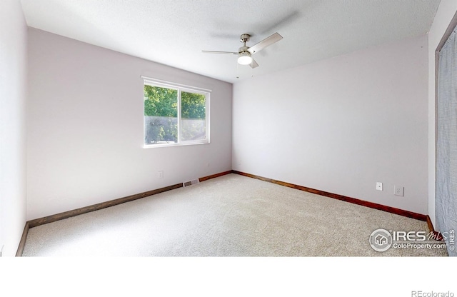 spare room featuring carpet flooring, a ceiling fan, and baseboards