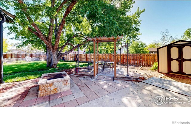 view of patio with a storage shed, a fire pit, and an outbuilding