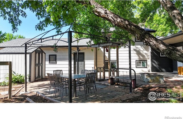 view of patio / terrace with a storage shed, an outdoor structure, and outdoor dining space