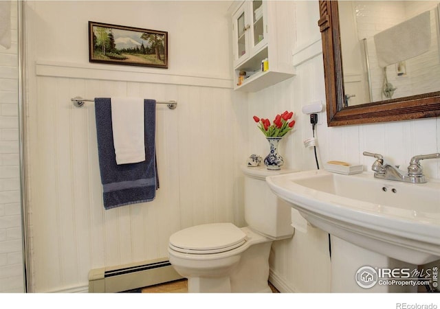 2219 Meadow Green Cir, Franktown, CO 80116 - bathroom with a baseboard heating unit, toilet, a sink, and wainscoting