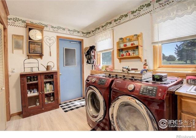 2219 Meadow Green Cir, Franktown, CO 80116 - laundry room with independent washer and dryer, light wood-style flooring, and cabinet space