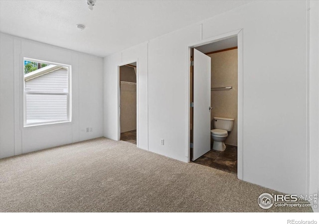 830 1st St # 14, Pierce, CO 80650 - unfurnished bedroom featuring carpet, a spacious closet, and ensuite bath
