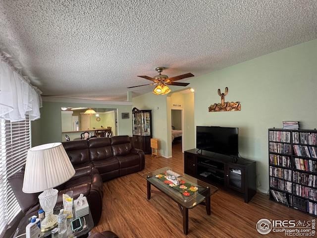 living area with a textured ceiling, wood finished floors, and a ceiling fan
