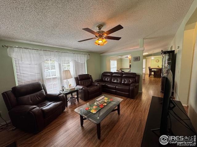 living area featuring ceiling fan, a textured ceiling, and wood finished floors